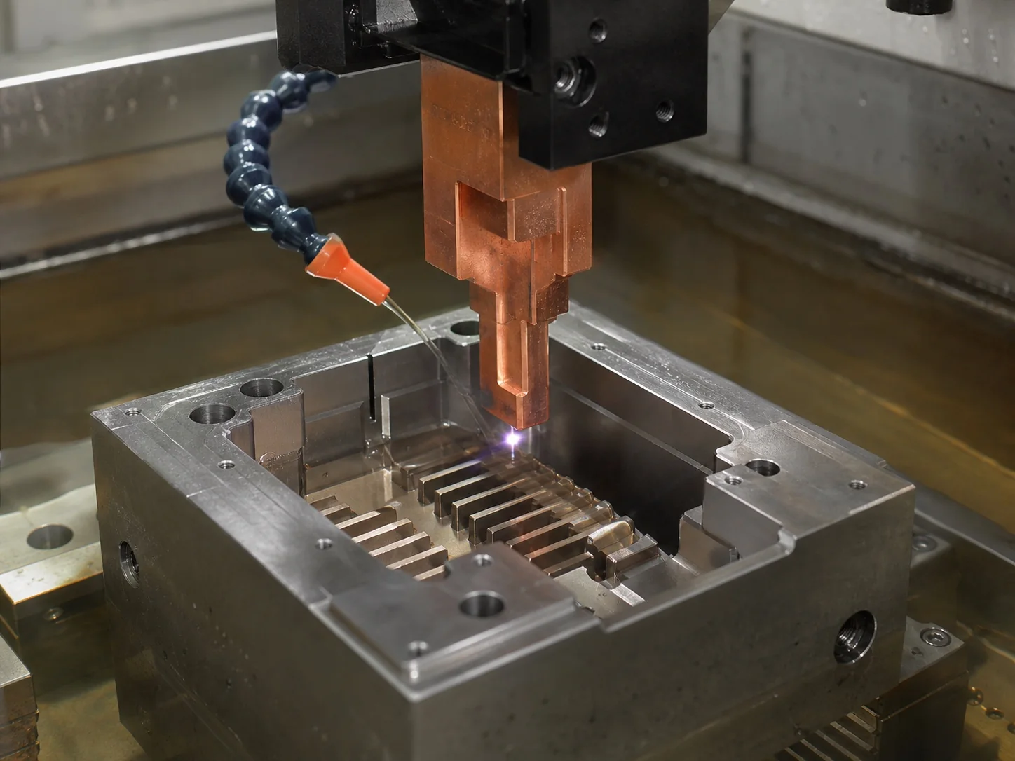 Copper die-sinking EDM electrode forming a cavity in a steel mold block